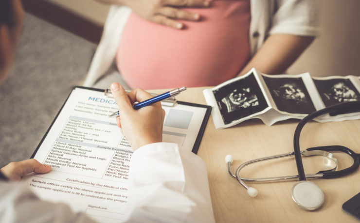 Doctor going through pre-birth maternity benefits with pregnant patient