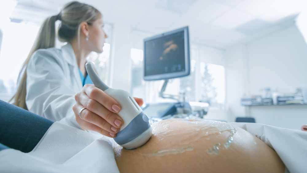 Female doctor performing ultrasound scan on pregnant patient Female doctor performing ultrasound scan on pregnant patient
