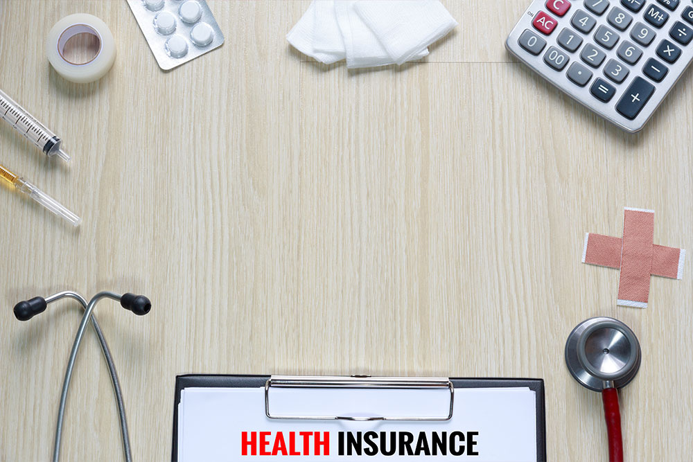 Health-professionals-desk-with-medical-insurance-form Health professional’s desk with medical insurance form, stethoscope, medication, and band aids